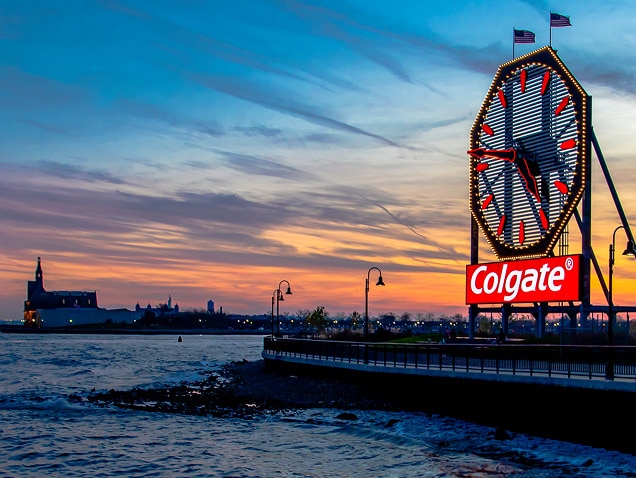 Havsstrand, Colgate-logotyp i bakgrunden under en stor klocka med röda visare